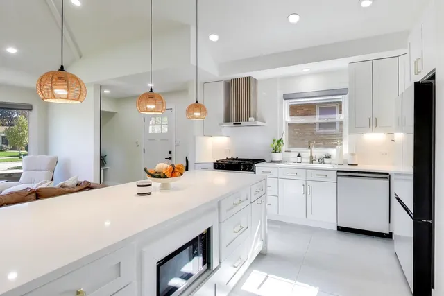 a large kitchen with kitchen island a large island a stove a table and chairs