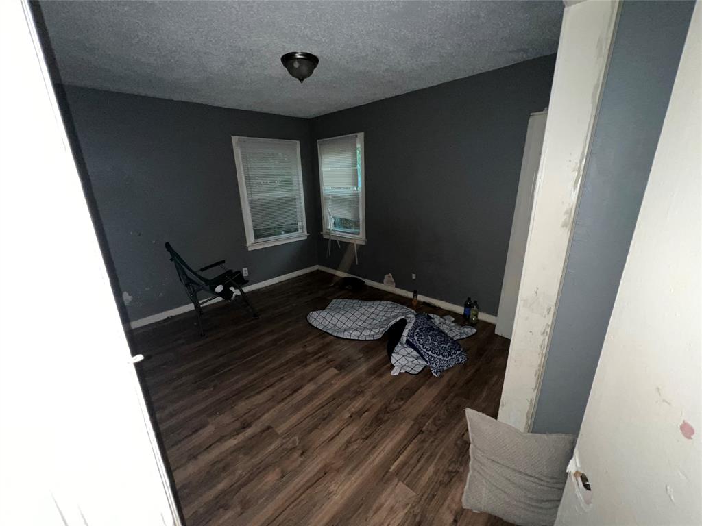 4224 Ramey Avenue Fort Worth, TX 76105 - Photo 17 of 19 Unfurnished room with dark wood-style flooring and a textured ceiling
