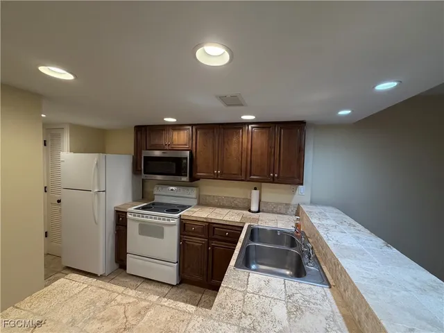 a kitchen with a sink a refrigerator and cabinets