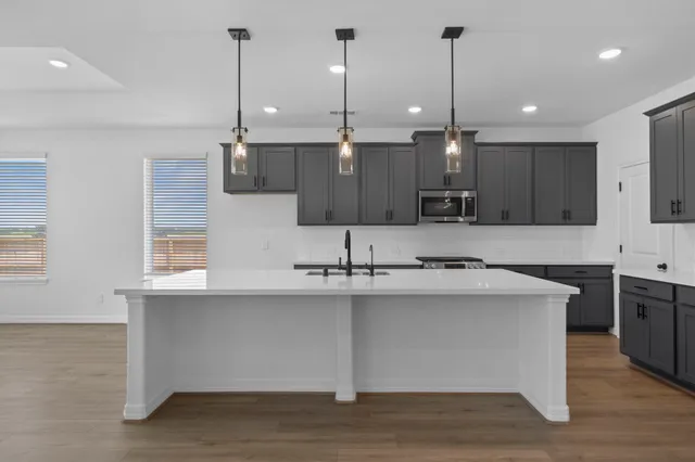 a kitchen with kitchen island a sink stainless steel appliances and cabinets