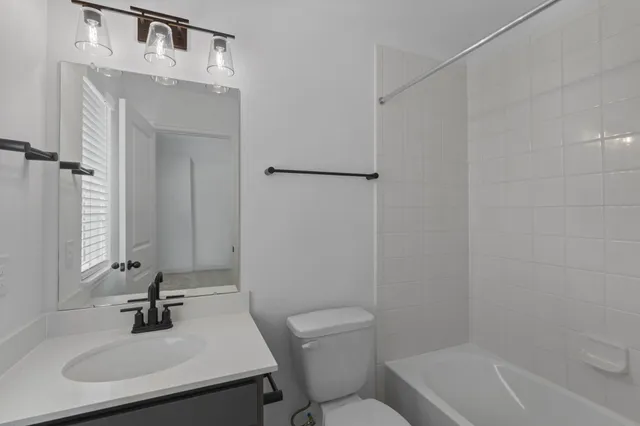 a bathroom with a sink toilet a mirror and shower