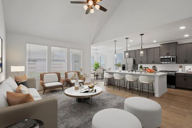 a living room with furniture kitchen view and a large window