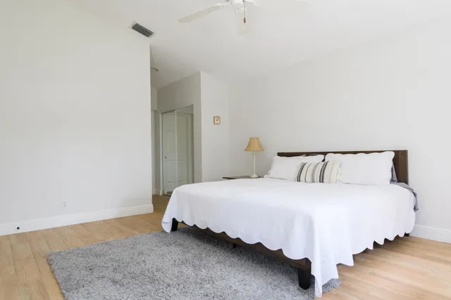 a bedroom with a bed and wooden floor