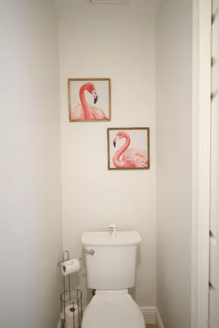 a white toilet sitting next to a white wall