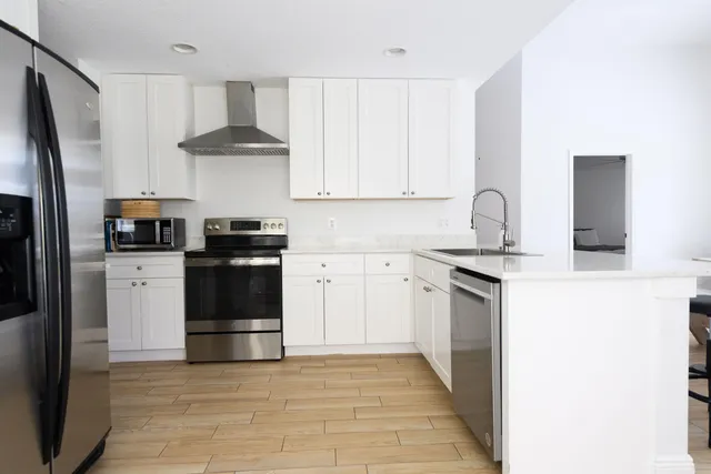 a kitchen with stainless steel appliances a refrigerator sink and cabinets
