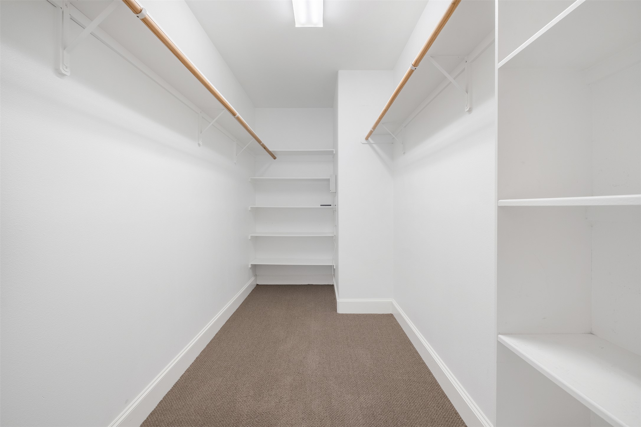 6715 Windrift Way, Unit 8 Austin, TX 78745 - Photo 16 of 24 A well-organized walk-in closet offers ample storage with integrated shelving and hanging rods.