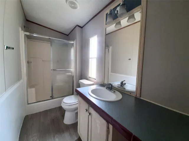 a bathroom with a granite countertop sink toilet and shower