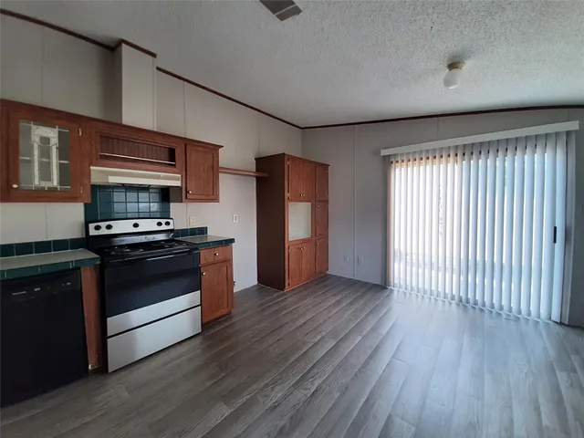 a kitchen with granite countertop wooden floors and stainless steel appliances