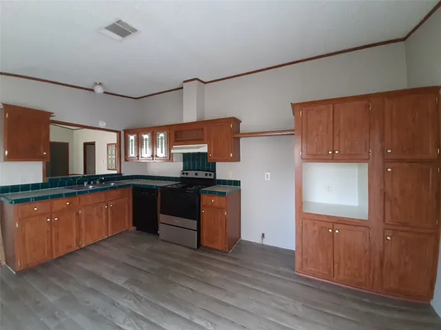 a kitchen with stainless steel appliances granite countertop a sink and wooden floors