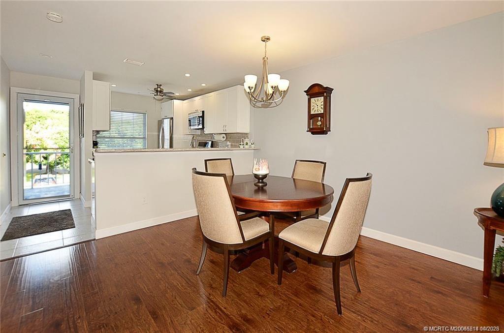 1854 Southwest Palm City Road, Unit 203 Stuart, FL 34994 - Photo 16 of 38 Light and bright dining area flows seamlessly into the updated kitchen featuring white cabinetry, granite countertops, stainless steel appliances, and a convenient breakfast bar that will seat six!