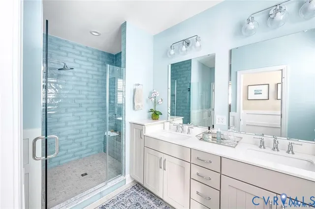 a bathroom with a double vanity sink mirror and shower