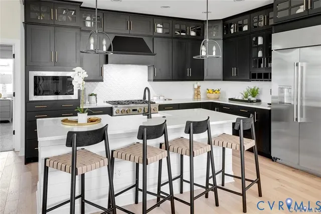 a kitchen with stainless steel appliances a dining table chairs microwave and sink