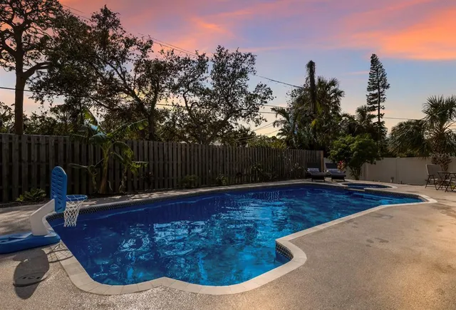 a view of a backyard with table and chairs and a large tree