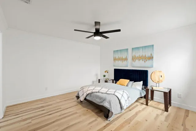 a bedroom with a bed and wooden floor