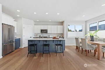33632 Northeast 42nd Street Carnation, WA 98014 - Photo 12 of 28 a kitchen with a dining table chairs refrigerator and cabinets