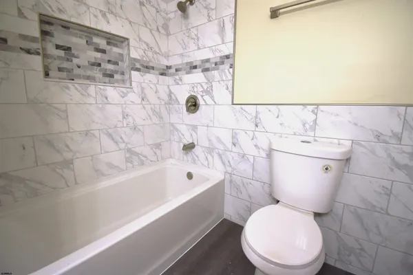 a white toilet sitting next to a bath tub