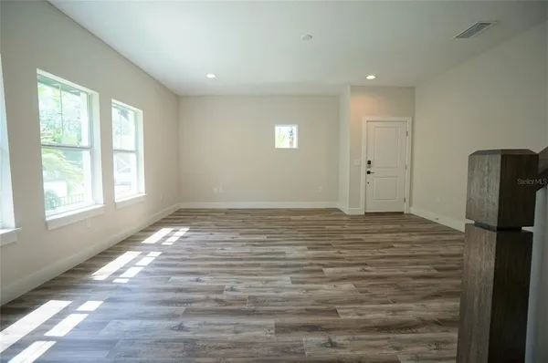 a view of empty room with window and refrigerator