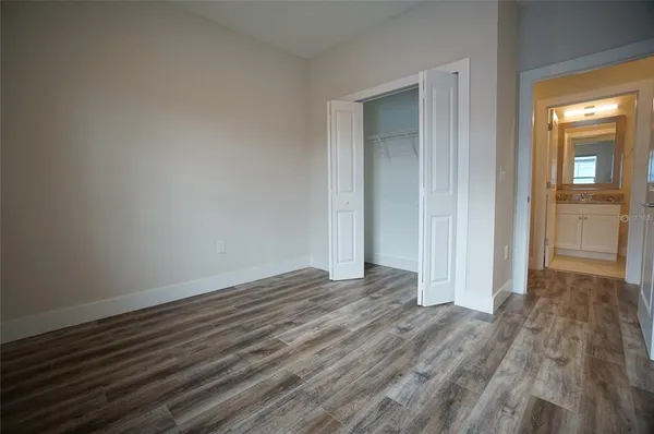 a view of a room with wooden floor and a bathroom