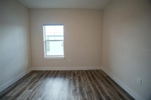 a view of a room with wooden floor and window