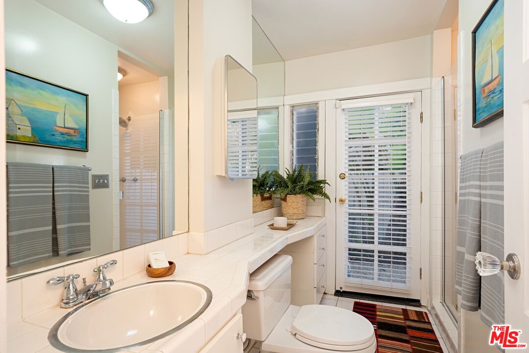 216 West Channel Road Santa Monica, CA 90402 - Photo 17 of 37 a bathroom with a sink toilet a mirror and shower