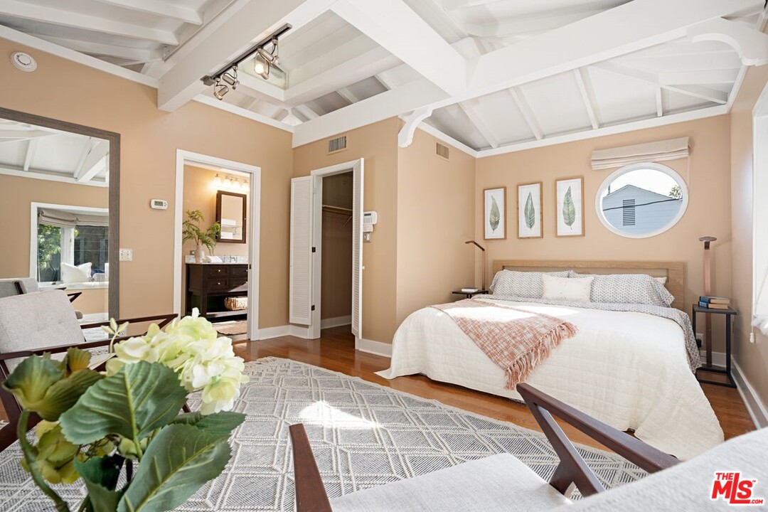 216 West Channel Road Santa Monica, CA 90402 - Photo 31 of 37 a bedroom with a bed mirror and paintings on the wall