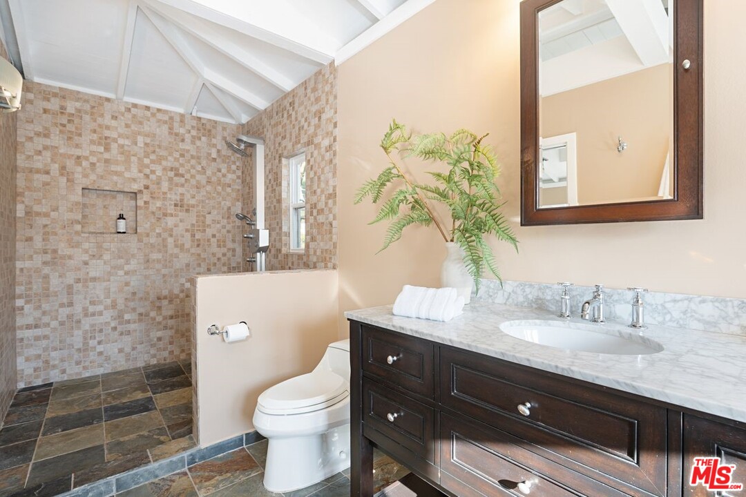 216 West Channel Road Santa Monica, CA 90402 - Photo 36 of 37 a bathroom with a granite countertop toilet sink and mirror