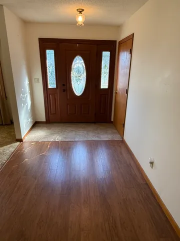 an empty room with wooden floor and a window