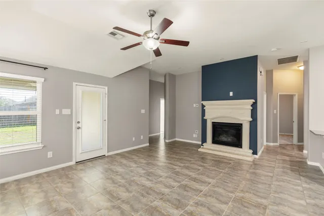 an empty room with fireplace and windows