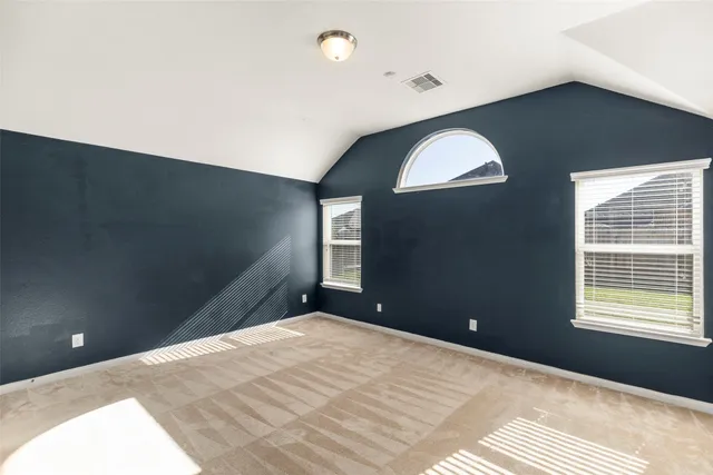 a bedroom with a bed and a refrigerator