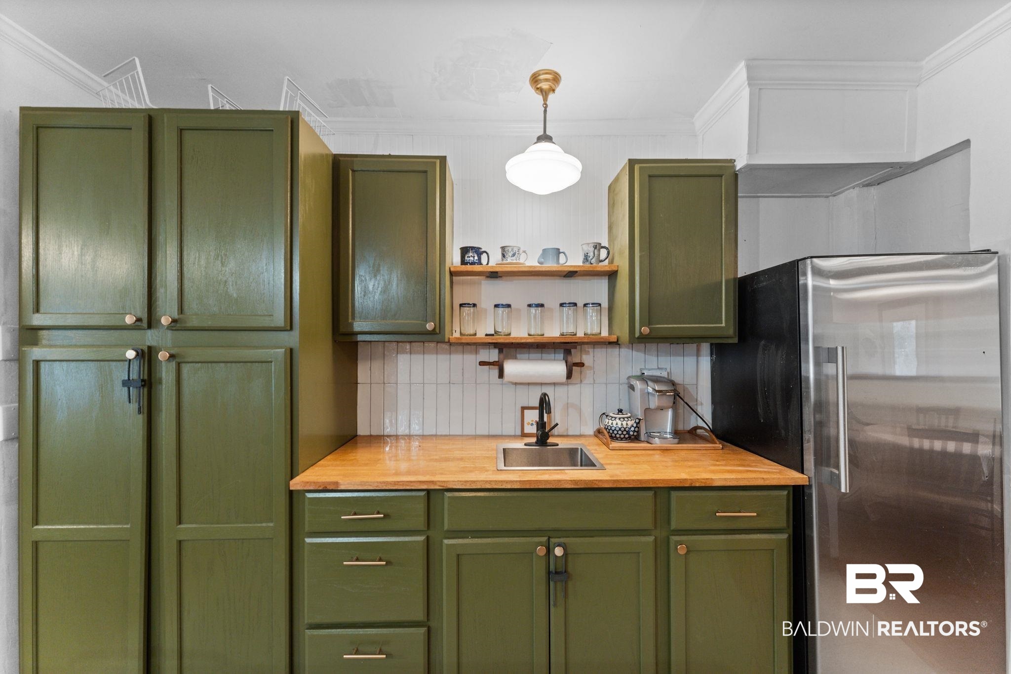 10785 Gregg Road Semmes, AL 36575 - Photo 6 of 35 Kitchen with green cabinets, stainless steel refrigerator, backsplash, ornamental molding, and pendant lighting