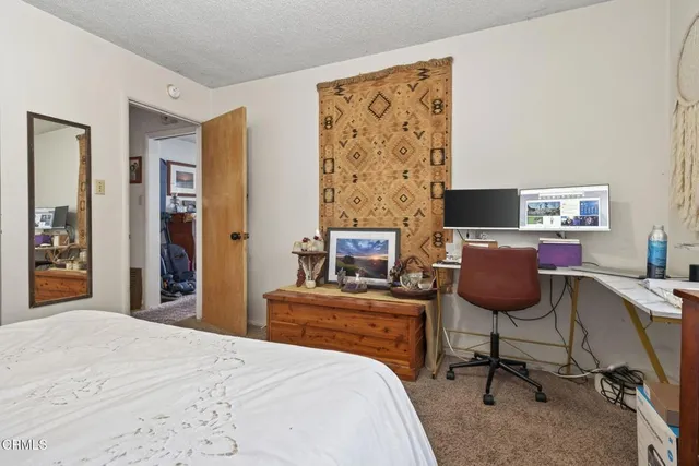 a bedroom with a bed and a desk