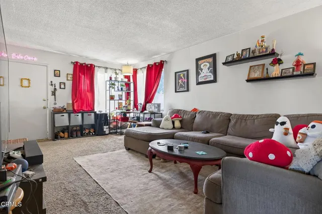 a living room with furniture a flat screen tv and a dresser