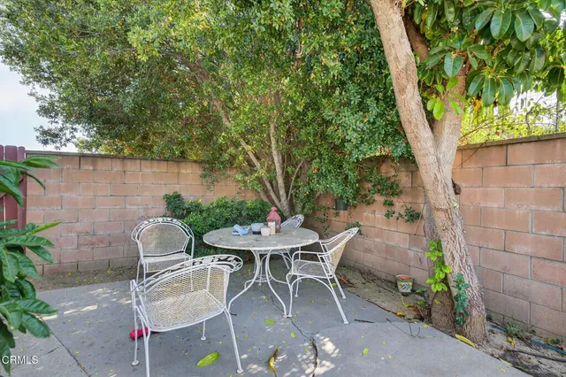 a view of a patio with table and chairs and potted plants