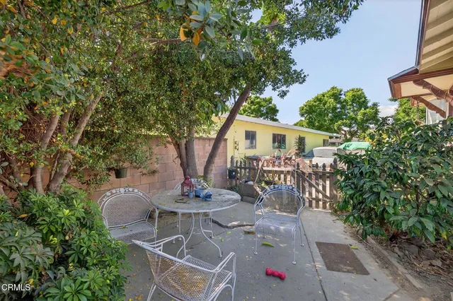 a view of a patio with table and chairs and potted plants