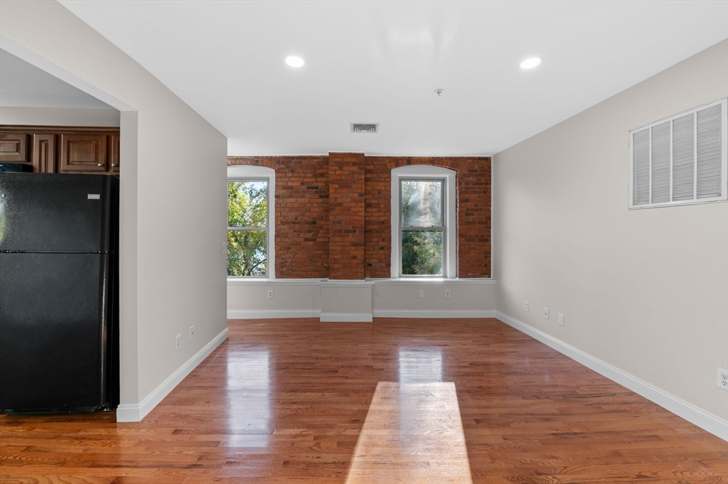 72 River Street, Unit 6 Haverhill, MA 01832 - Photo 11 of 40 a view of an empty room with wooden floor and a window