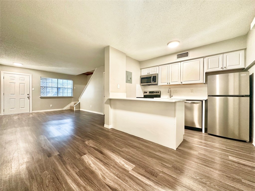 1200 Banister Lane, Unit 4 Austin, TX 78704 - Photo 6 of 15 a kitchen with stainless steel appliances a refrigerator sink and cabinets