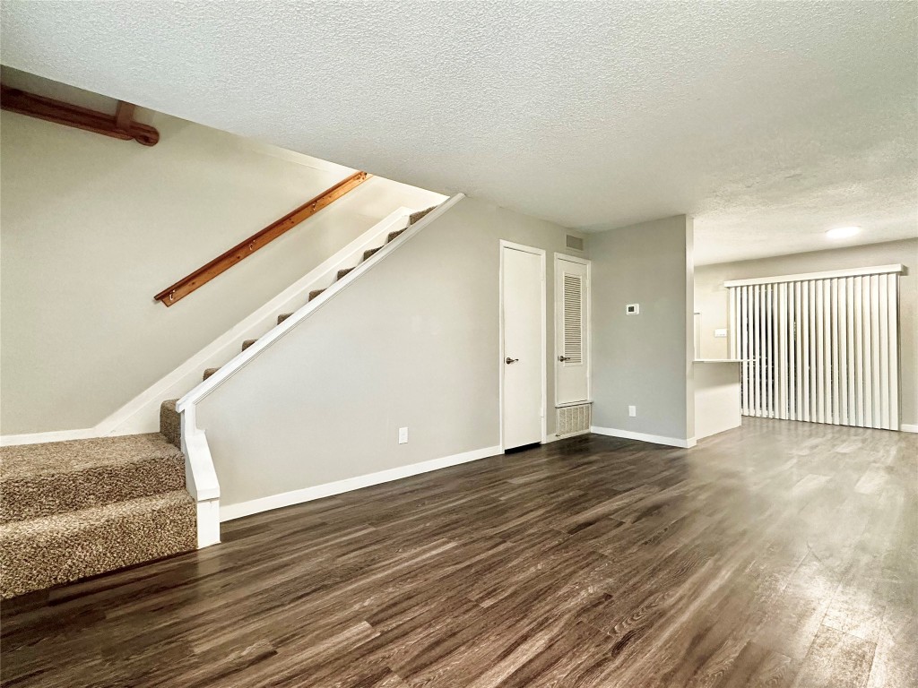 1200 Banister Lane, Unit 4 Austin, TX 78704 - Photo 8 of 15 a view of an empty room with wooden floor and stairs