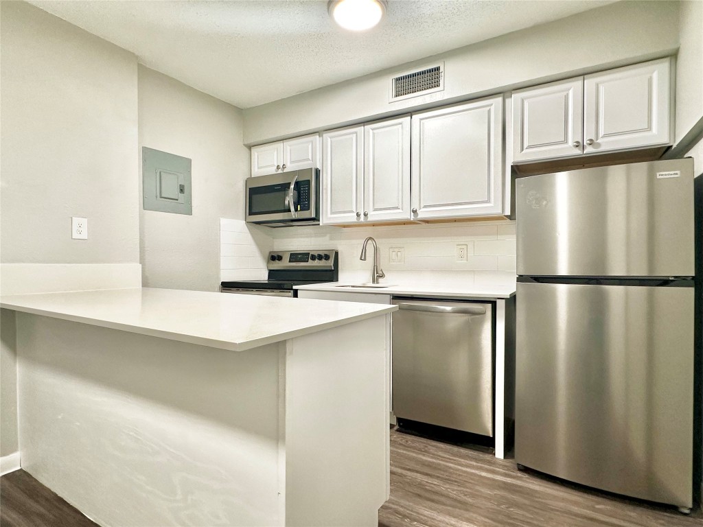 1200 Banister Lane, Unit 4 Austin, TX 78704 - Photo 10 of 15 a kitchen with stainless steel appliances granite countertop a refrigerator a stove a sink a microwave and cabinets