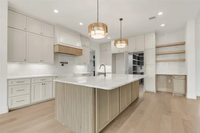 a kitchen with cabinets and chandelier
