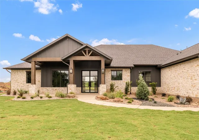 a front view of a house with a yard outdoor seating and garage