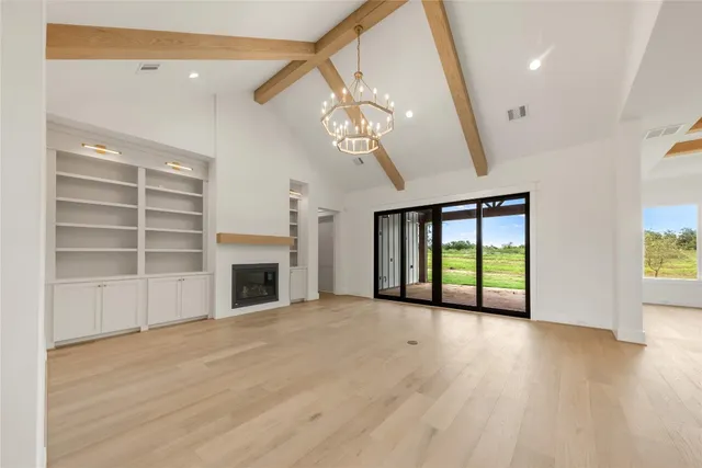 a view of an empty room with a fireplace and a window