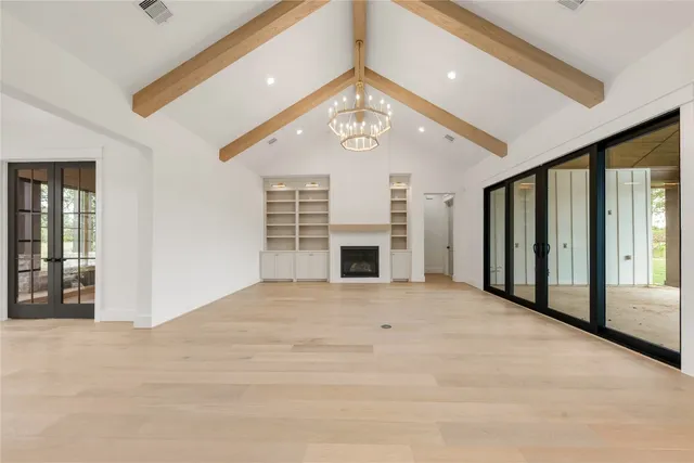 a view of a livingroom with a fireplace a ceiling fan and windows