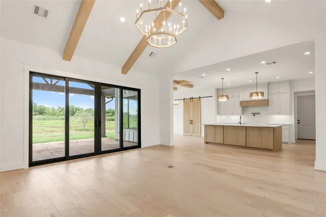 a kitchen with kitchen island granite countertop wooden cabinets and a chandelier