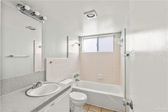 a bathroom with a granite countertop sink toilet a shower and a mirror