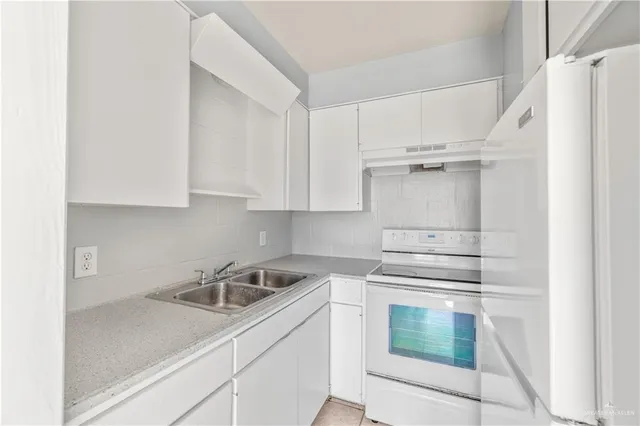 a kitchen with white cabinets and white appliances