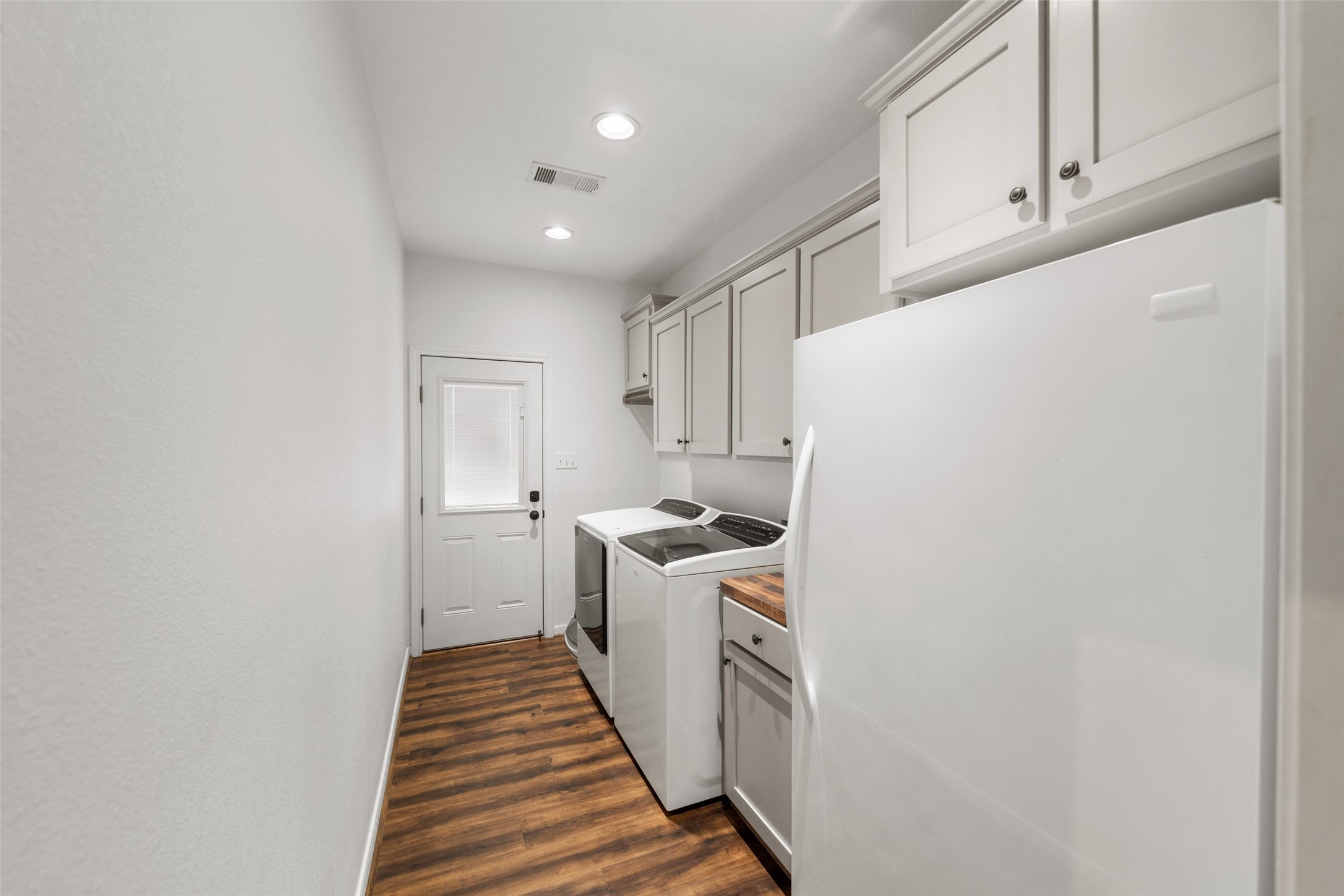 1121 Pelican Road Shepherd, TX 77371 - Photo 16 of 34 Functional utility room with built-in cabinetry, wood countertops, and space for additional storage or appliances, plus convenient exterior access.