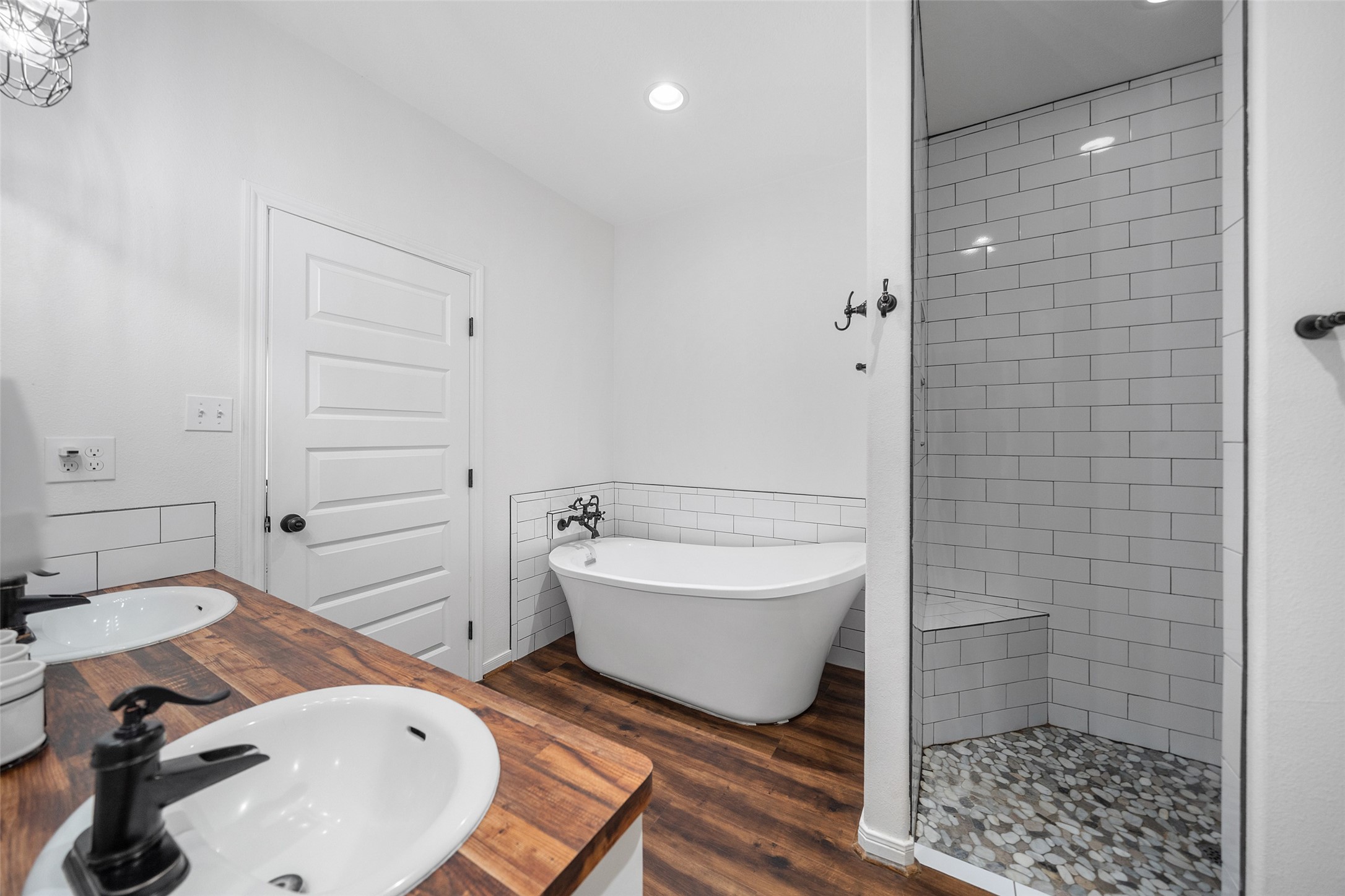 1121 Pelican Road Shepherd, TX 77371 - Photo 20 of 34 Spa-inspired bath featuring a freestanding soaking tub, walk-in tiled shower, and dual vanities with warm wood countertops for a stylish farmhouse touch.