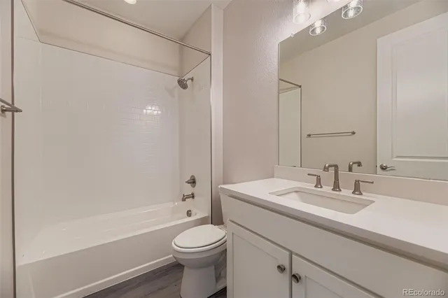 a bathroom with a sink toilet vanity and shower