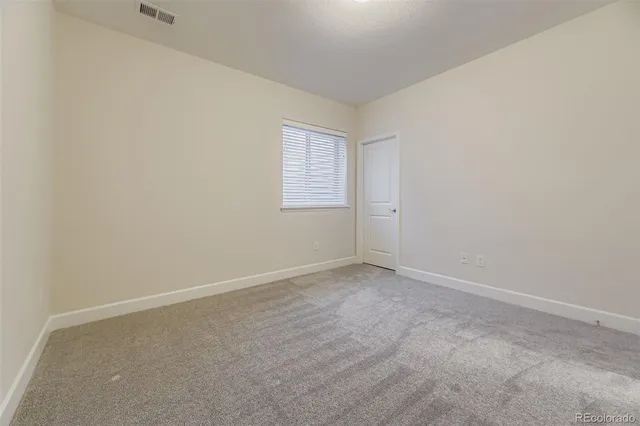 a view of an empty room with a kitchen