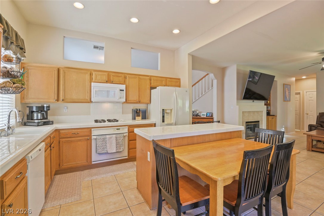 2356 Tilden Way Henderson, NV 89074 - Photo 12 of 30 A well-lit kitchen with natural wood cabinetry and a functional central island.